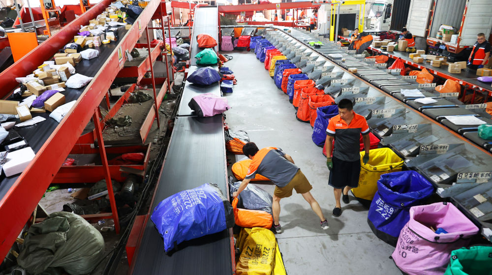 江苏省连云港市公共配送中心工作人员分拣、发送快递包裹（2025年6月18日摄）。新华社发（耿玉和摄）.jpg